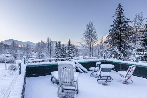 a yard covered in snow with chairs and a pool at Alyeska North #400 in Girdwood