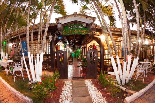a restaurant with palm trees in front of a building at Pousada Sonho da Lagoa in Praia do Forte