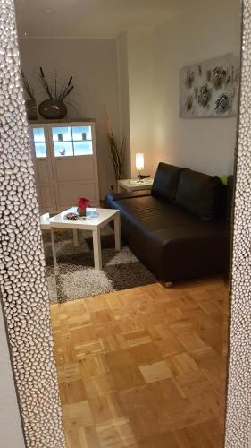 a living room with a black couch and a table at Ferien-& Monteurwohnung Koenen2 nah am Westfield Centro in Oberhausen