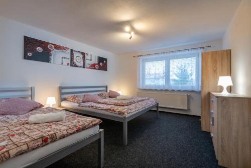 una camera da letto con due letti e una finestra di A&A Apartmany a Liptovský Mikuláš
