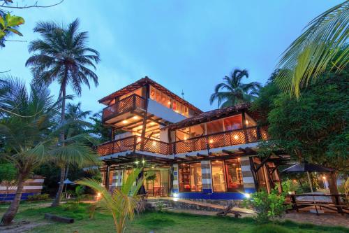 a house on the beach with palm trees at La Mar de Bien in Buritaca