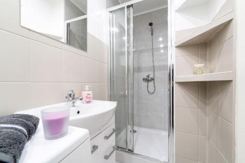 a white bathroom with a shower and a sink at Apartament Kortowski in Olsztyn