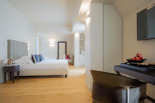 a bedroom with a bed and a tv on a wall at Hotel Politeama in Palermo