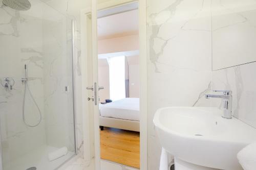 a white bathroom with a sink and a shower at Hotel Politeama in Palermo