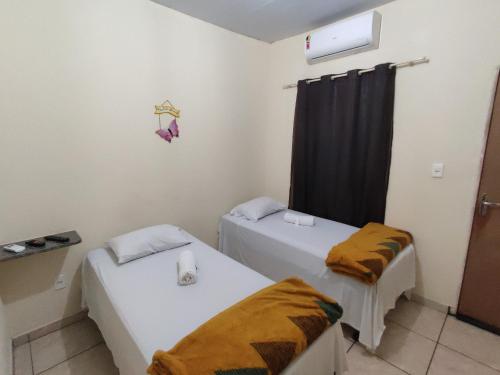 a room with two beds and a window at Pousada do Professor in Pirenópolis