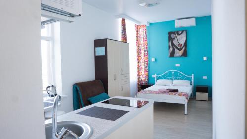 een badkamer met een wastafel en een slaapkamer met een bed bij Doba In Ua Luhovska255 Apartments in Dnipro
