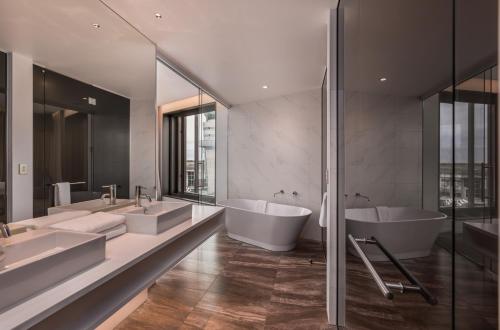 クライストチャーチにあるNovotel Christchurch Airportのバスルーム(シンク2台、バスタブ2つ付)