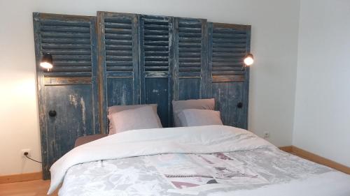 a bedroom with a bed and a wooden wall at Le Jardinet in Pont-Sainte-Maxence