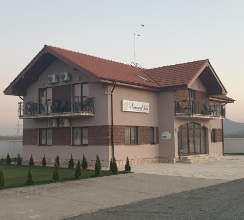 a building with a balcony on the side of it at Pensiunea Oana ☆☆☆ in Şoimuş