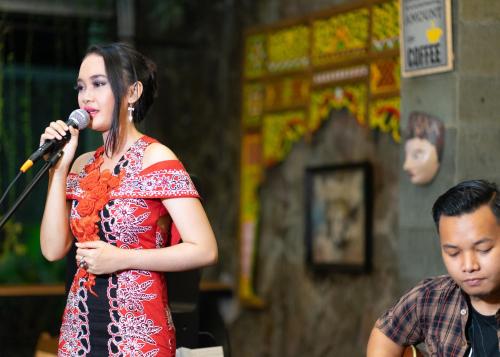 a girl singing into a microphone next to a boy at Baratha Hotel & Resto in Bondowoso