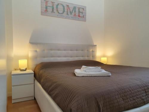um quarto com uma cama com um cobertor e 2 candeeiros em Lake House - Milano 3 em Basiglio