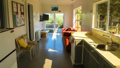 a kitchen and a living room with a couch at Marahau Beach Camp in Marahau