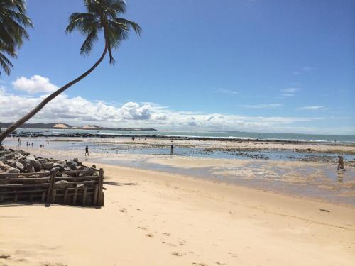 a sandy beach with palm trees and palm trees at Pousada Barbara in Pipa