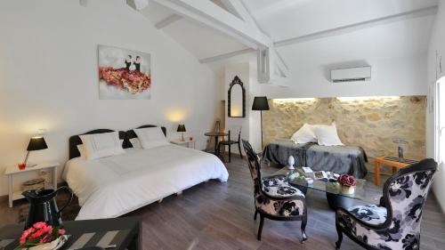 Saint-Julien-dʼArmagnacにあるGîtes La Ferme et la Bergerie de Monseignonのベッドルーム1室(ベッド2台、テーブル、椅子付)