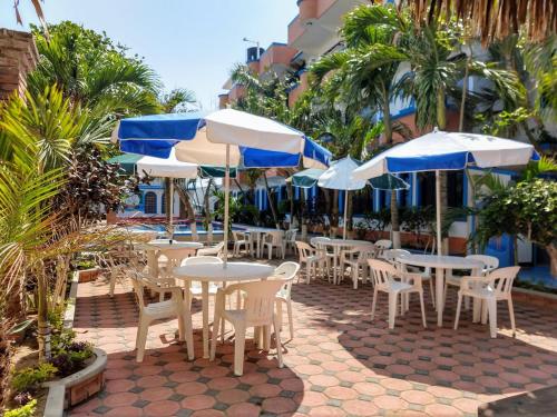 un grupo de mesas y sillas con sombrillas en Hotel Real del Quijote a sólo 50 metros de la playa, en Tecolutla