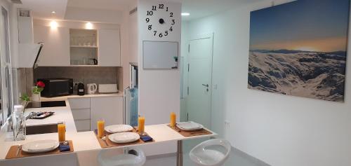 a white kitchen with a table and two chairs at ecoSmart Apartments in Granada