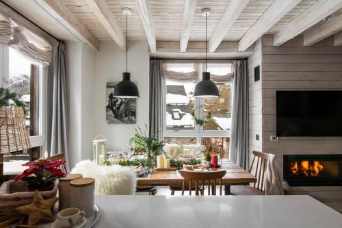 un salon avec une table et une cheminée dans l'établissement Baqueira-Beret ERA CABANA, Salardu+Parking Val de Ruda, à Salardú