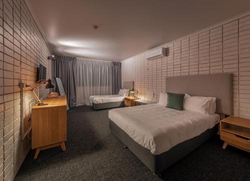 a hotel room with two beds and a television at Palms Hotel in Sydney