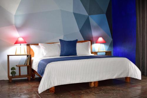 a bedroom with a large bed with blue and white at Tlaquepaque Pueblito in Guadalajara