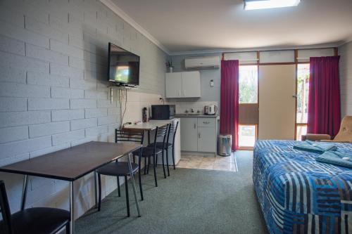 a room with a bed and a kitchen with a table at Murray Bridge Motor Inn in Murray Bridge