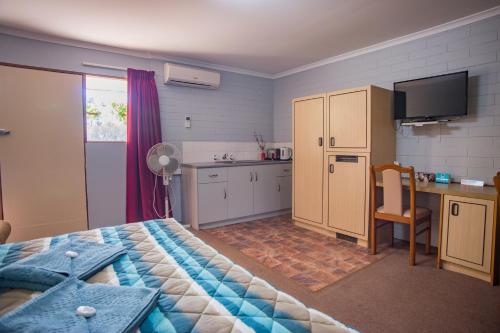 ein Schlafzimmer mit einem Bett und einem Schreibtisch sowie eine Küche in der Unterkunft Murray Bridge Motor Inn in Murray Bridge