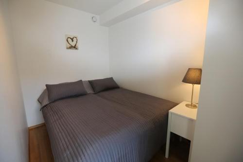 a bedroom with a bed and a night stand with a lamp at OSLO CITY CENTER 3 BEDROOMS APARTMENT, MANDALLS GATE 12 in Oslo