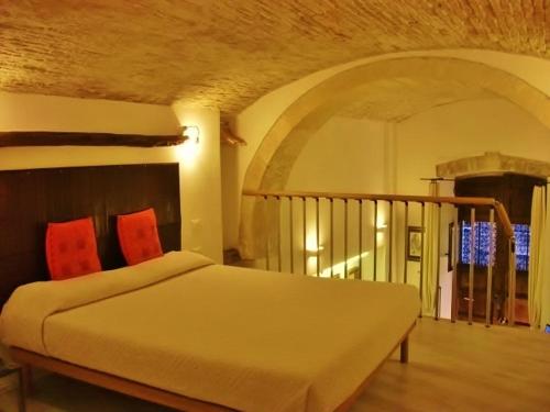 a bedroom with a bed with red pillows on it at Residenze Palazzo Pes in Cagliari