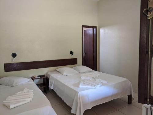a hotel room with two beds with towels on them at Pousada Canto do Rio in Três Marias