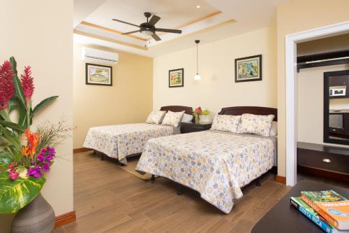 a hotel room with two beds and a table at Airport Costa Rica B&B in Alajuela City