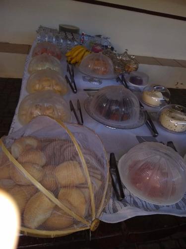 a table topped with plastic containers filled with bread at Pousada do Professor in Pirenópolis
