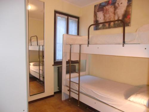 Pokój z 2 łóżkami piętrowymi i lustrem w obiekcie Appartamento Belvedere w mieście Molina di Ledro