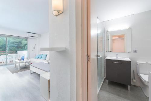 La salle de bains blanche est pourvue d'un lavabo et de toilettes. dans l'établissement Nice Studio in Siesta 2 in Puerto Alcudia 2, à Alcúdia