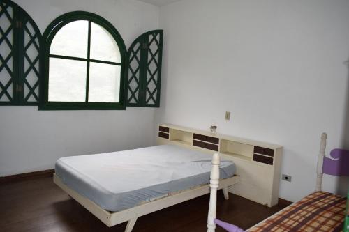 a bedroom with a bed and a window at Chácara Dona Eulália in Monte Alegre do Sul