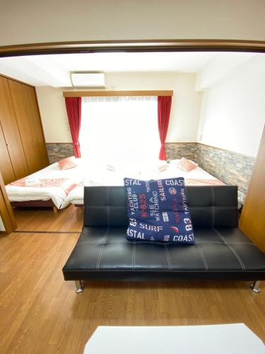 a living room with a couch and two beds at Laforet Tokaichi in Hiroshima