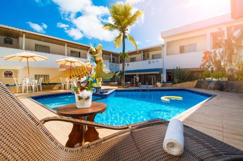 a swimming pool in front of a house at Shangrilá - Rede Soberano in Porto Seguro