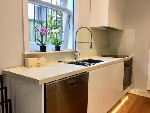 una cocina con fregadero y ventana en 3BR Terrace House in Darling Habour, next to ICC and The Star, Sydney CBD, Free parking, en Sídney