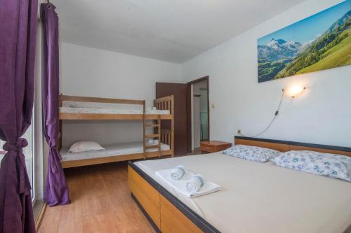 a bedroom with a bed and a bunk bed at Apartments Ante in Bogomolje