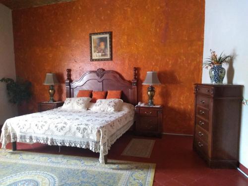 a bedroom with a bed and two dressers and two lamps at Hotel Spa Hacienda Real la Nogalera in Tequisquiapan