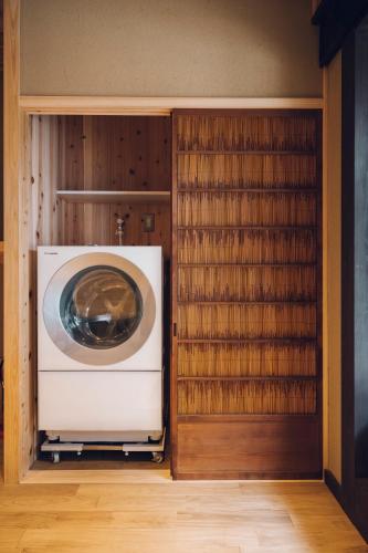 a washer and dryer in a room with wooden shelves at Someno House Kyoto Dog Friendly in Kyoto