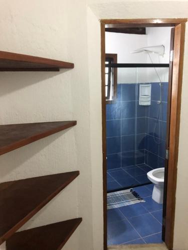 uma casa de banho com um WC e uma porta de duche em vidro. em Tranquilidade e Sossego em Ilhabela em Ilhabela