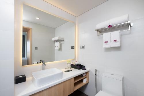 a bathroom with a sink and a mirror at Carinae Danang Hotel in Danang