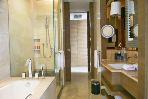 a bathroom with a tub and a sink and a shower at Crowne Plaza Nanjing Jiangning by IHG in Nanjing