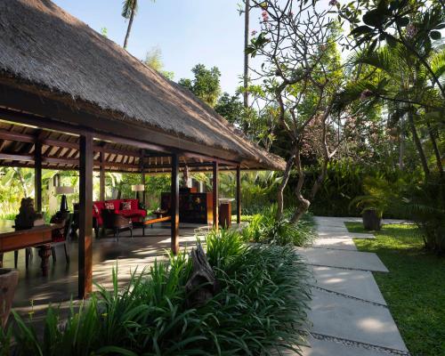 a pavilion with a thatched roof in a garden at Kayumanis Jimbaran Private Villas & Spa in Jimbaran