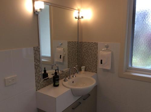 a white bathroom with a sink and a mirror at Forrest River Valley in Forrest