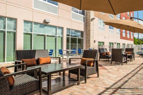 a patio with chairs and tables and an umbrella at Holiday Inn Express & Suites - Tampa North - Wesley Chapel by IHG in Wesley Chapel
