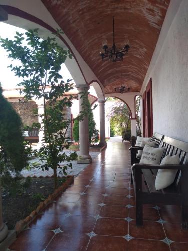 an outdoor porch with a couch and a chandelier at Hotel Spa Hacienda Real la Nogalera in Tequisquiapan