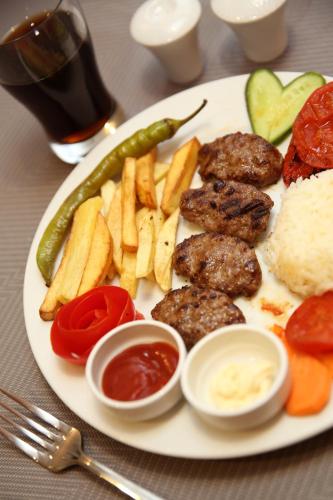 a plate of food with meat and vegetables on a table at Hotel Expocity Istanbul in Avcılar