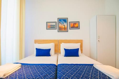 a bedroom with two beds with blue pillows at Oceanfront Condominium - Nilaveli in Nilaveli