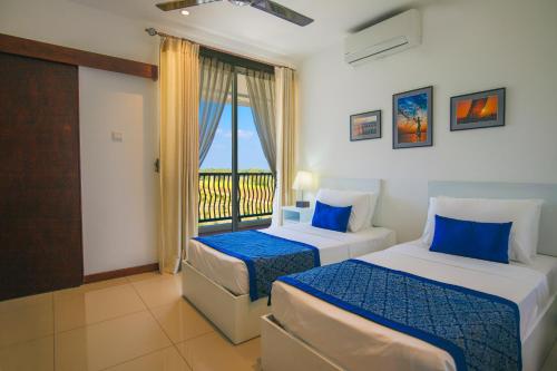 Ліжко або ліжка в номері Oceanfront Condominiums - Nilaveli