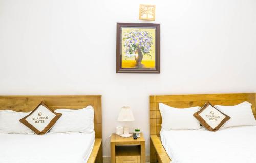 1 dormitorio con 2 camas y una foto en la pared en Xuan Dan Hotel, en Ho Chi Minh